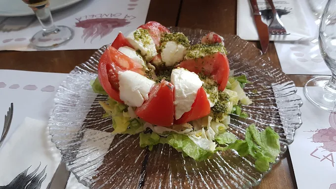 Ensalada de tomate, mozzarella y pesto sobre lechuga